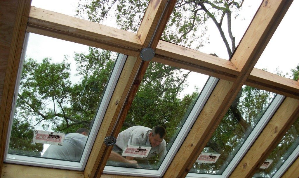 A man is working on the roof of his house.