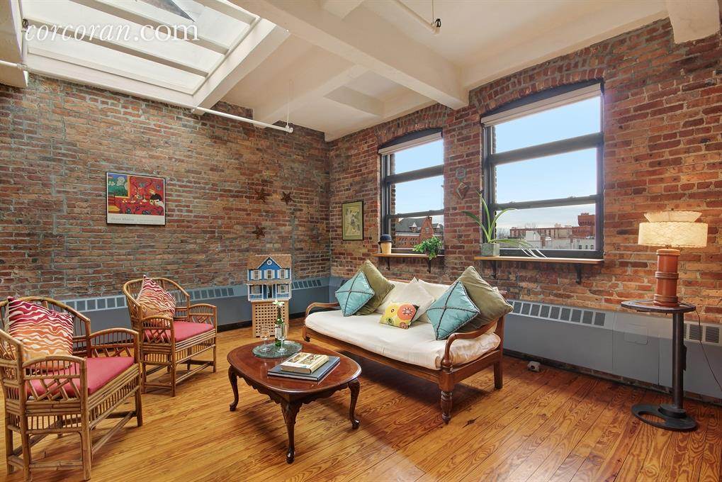 A living room with wooden floors and brick walls.