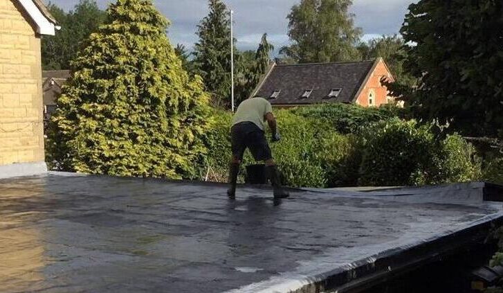 A man standing on top of a roof.