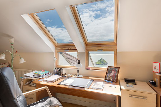 A desk with two windows and a laptop on it.