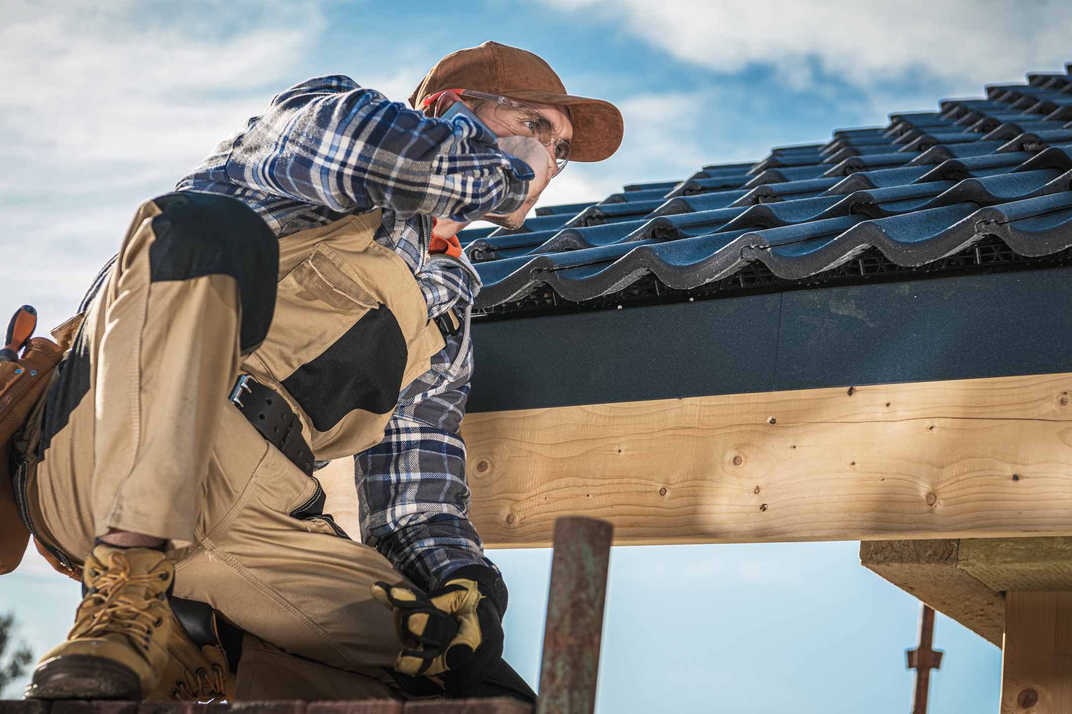 A man sitting on top of a wooden structure.